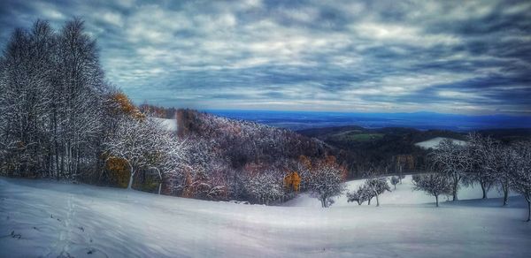 Snow covered landscape against sky