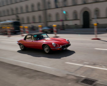 Red vintage car on street in city