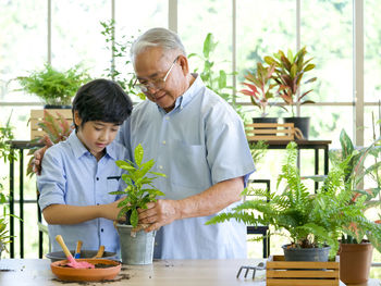 Friends standing on potted plant