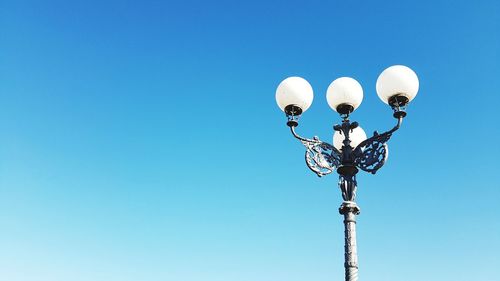 Low angle view of street light against clear blue sky