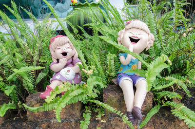 Figurines by plants at backyard