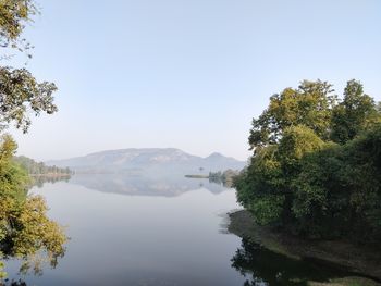 Scenic view of lake by trees against clear sky