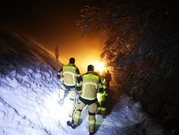 Fire fighters standing on snow covered landscape