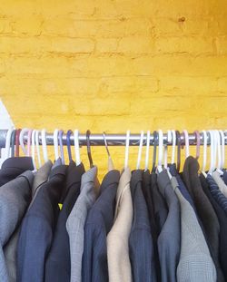 Close-up of clothes hanging on yellow wall
