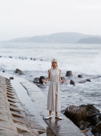 Rear view of woman standing at beach