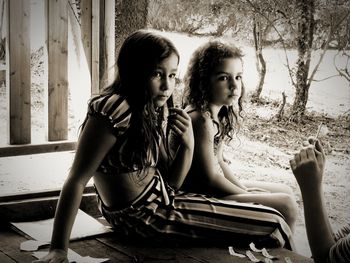Mother and girl sitting outdoors