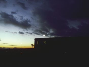 View of illuminated buildings against cloudy sky