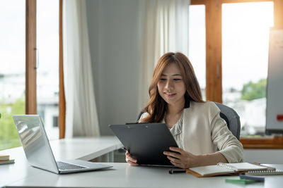 Young woman using laptop at office