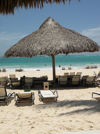 Chairs and tables on beach against blue sky