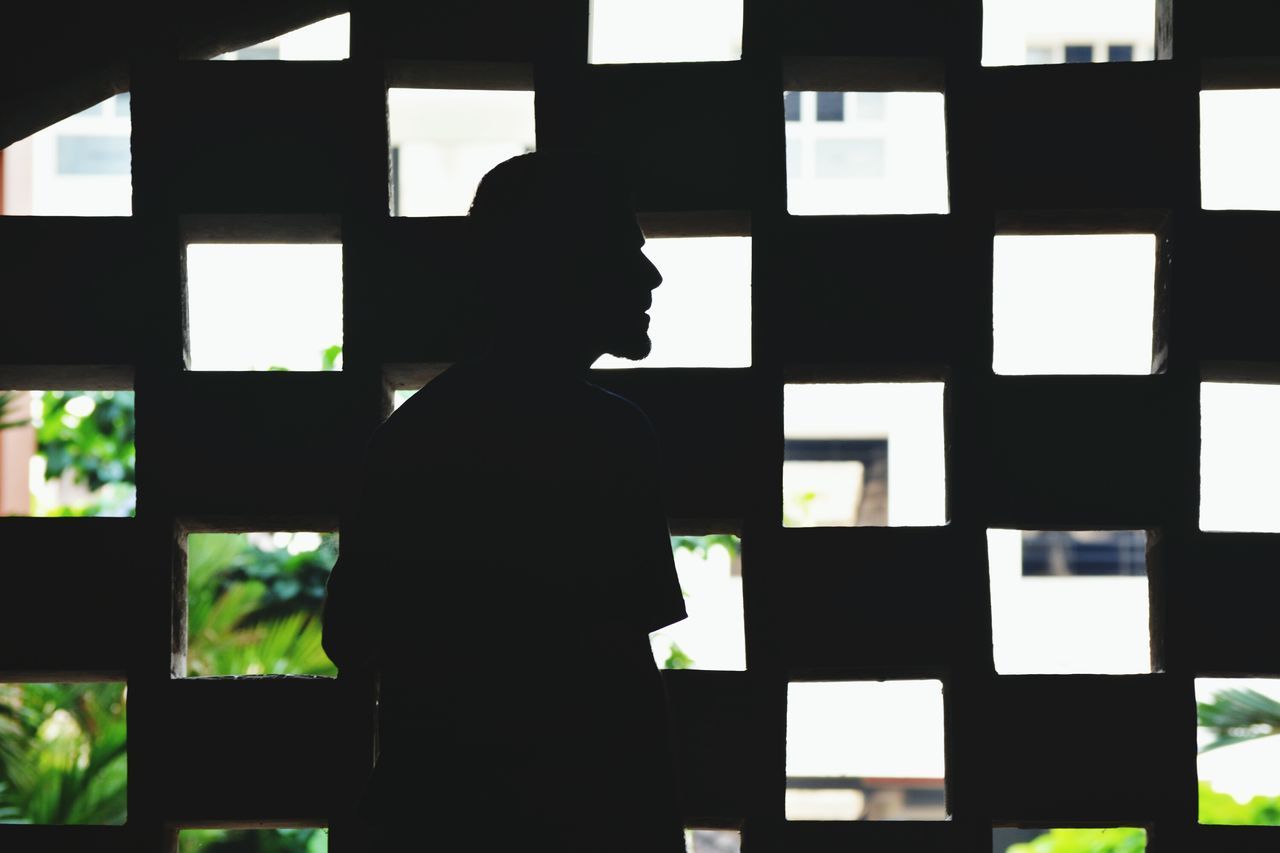 SILHOUETTE MAN STANDING IN FRONT OF WINDOW