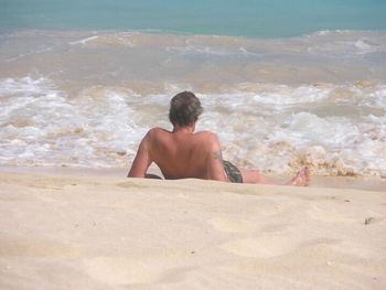 Rear view of shirtless man at beach