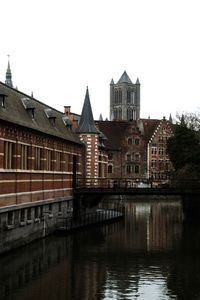 River by buildings against clear sky