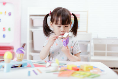 Young girl decorating hand made craft for homeschooling