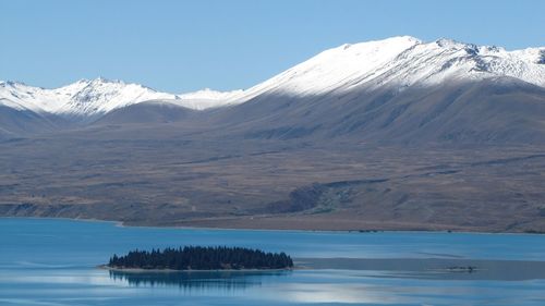 Scenic view of lake and snowcapped mountains against sky