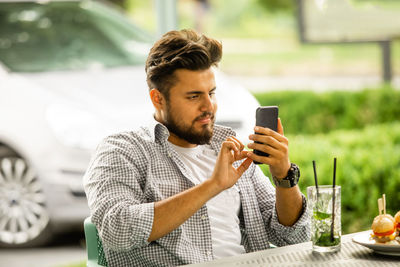 Young man looking away while sitting on table