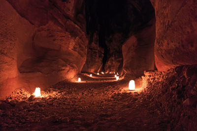Illuminated footpath amidst rock formations at petra