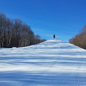 People on snow covered land against sky