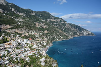 Scenic view of sea and mountains against blue sky