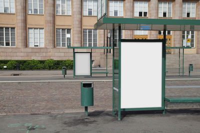 Empty chairs on street against building