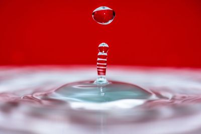 Close-up of water drop over colored background