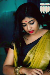 Woman wearing sari standing at home