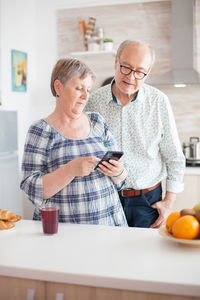 Senior couple using phone at home