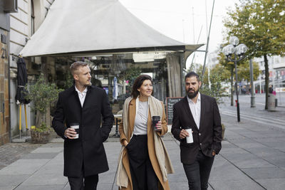 Low angle view of business colleagues standing in city