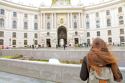 Rear view of woman standing against building