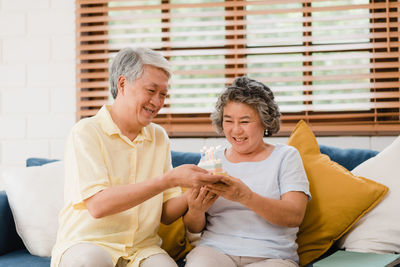 Happy friends sitting on sofa at home