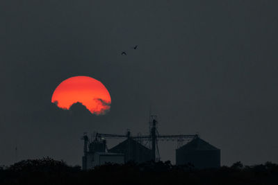 Silhouette buildings against sky at night