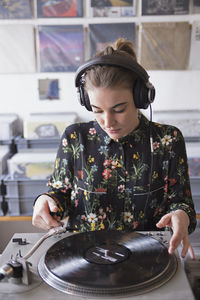 Young woman listening to record in a record store