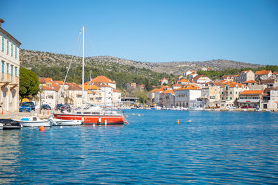 View of townscape by sea against clear sky