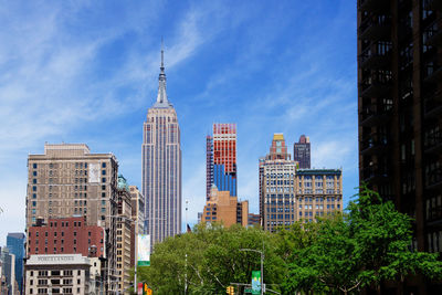 Buildings in city against cloudy sky