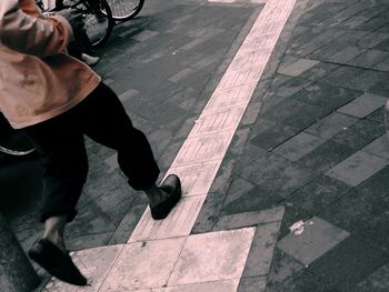 Low section of woman standing on tiled floor