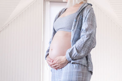 Side view of woman standing against wall