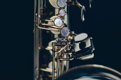 Close-up of saxophone against black background