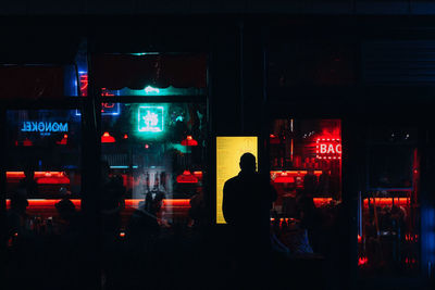 Man in illuminated city at night