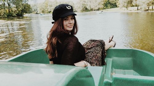 Portrait of smiling woman sitting in boat on lake