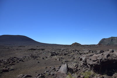 Scenic view of desert against clear blue sky