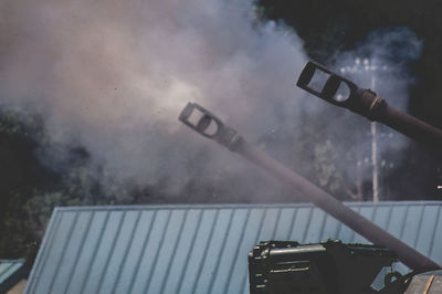 Low angle view of weapon and smoke during war