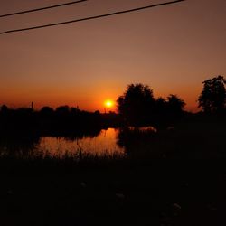 Scenic view of lake against orange sky