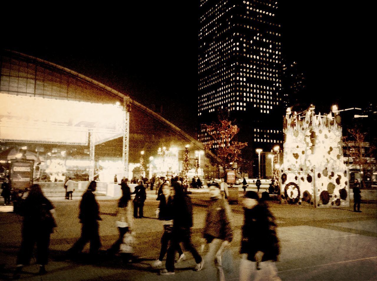 illuminated, night, large group of people, architecture, built structure, city life, city, men, person, transportation, street, walking, building exterior, lifestyles, lighting equipment, railroad station, road, city street, group of people