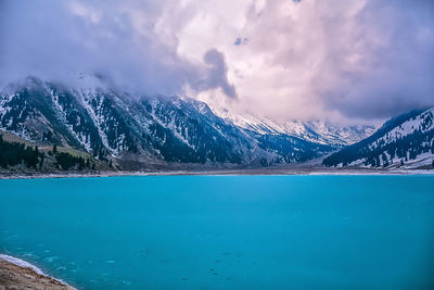 Scenic view of lake and snowcapped mountains against sky