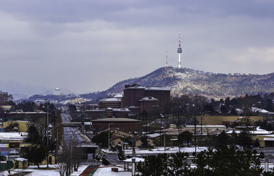 Buildings in city against cloudy sky