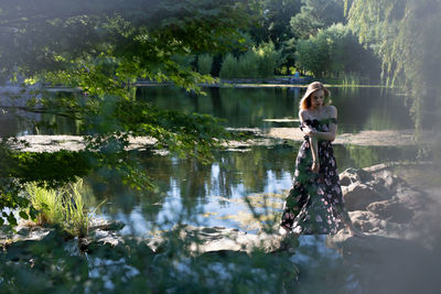 Woman in lake by trees