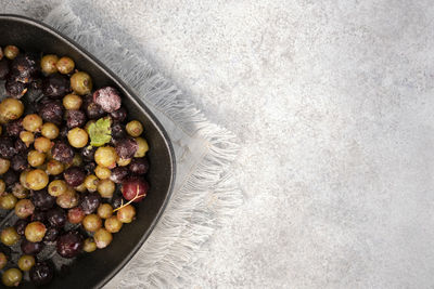 Frozen green and black currant on black pan. currant sauce is being prepared. top view. copy space.