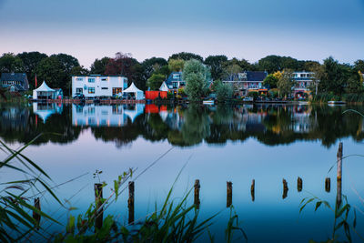 Scenic view of lake by buildings against sky