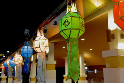 Low angle view of illuminated lanterns hanging by building at night