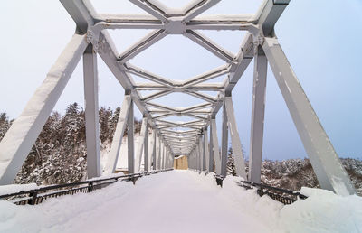 Snow covered bridge against sky