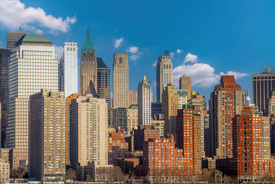 Modern buildings in city against blue sky